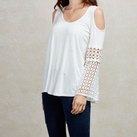 The Natasha top is a white relaxed fit cold shoulder top with crochet detailed sleeves.