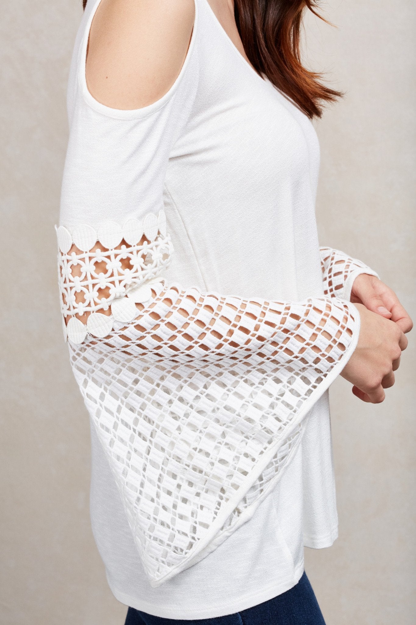 The Natasha top is a white relaxed fit cold shoulder top with crochet detailed sleeves.